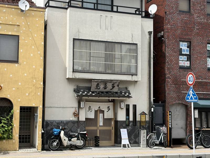 「鳥喜多」の木の看板と白いのれんが掛かる長浜の鳥喜多本店の店構え